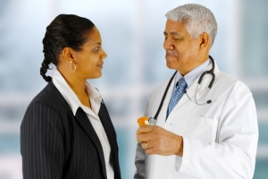 senior pharmacist with stethoscope talking with a female costumer